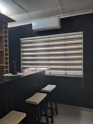 a bar with two stools and a window with blinds at Adam's Inn place in Hartbeespoort