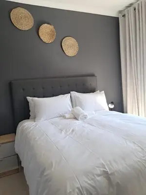 a bedroom with a white bed with three hats on the wall at Adam's Inn place in Hartbeespoort