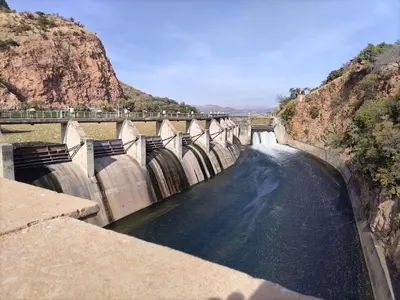 a bridge over a river with water flowing through it at Adam's Inn place in Hartbeespoort