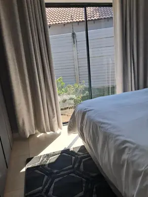 a bedroom with a bed and a large window at Adam's Inn place in Hartbeespoort