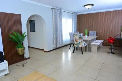 a living room with a table and chairs at Sublime Home in Bela-Bela