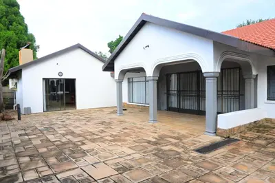a white building with a brick patio at Sublime Home in Bela-Bela