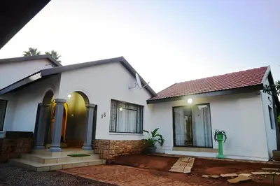 a white house with a green object in front of it at Sublime Home in Bela-Bela