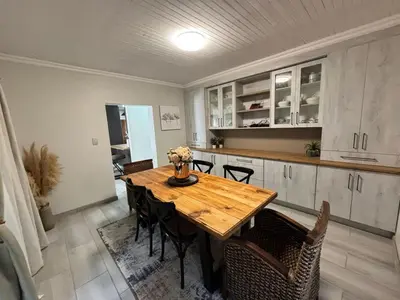 a kitchen with a wooden table and chairs at Shamba Self-Catering in Pretoria