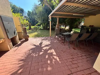 a patio with a table and chairs under awning at Shamba Self-Catering in Pretoria