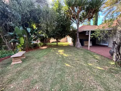 a yard with a bench in front of a house at Shamba Self-Catering in Pretoria