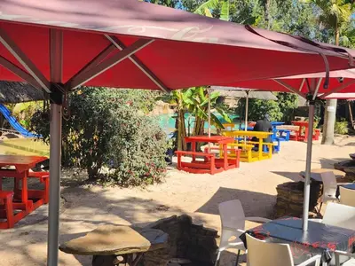 a red umbrella sitting on top of a table at Beach Island Graskop in Graskop