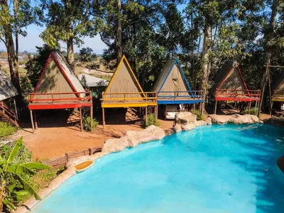 a group of huts with a pool in a yard at Beach Island Graskop in Graskop