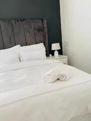 a white bed with a white blanket on it at Ekhaya Manor in Polokwane