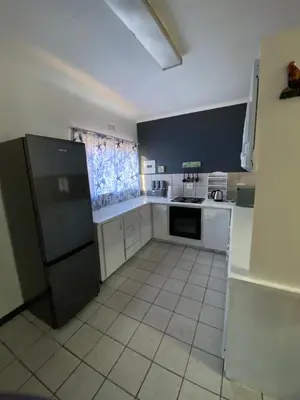 a kitchen with white appliances and a black refrigerator at Ekhaya Manor in Polokwane