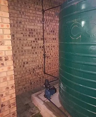 a green barrel sitting next to a brick wall at Little Swift 2 in Secunda