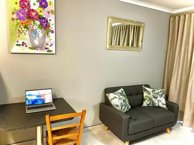 a living room with a couch and a table with a laptop at Little Swift 2 in Secunda