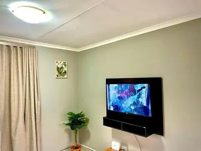 a flat screen tv sitting on the corner of a room at Little Swift 2 in Secunda
