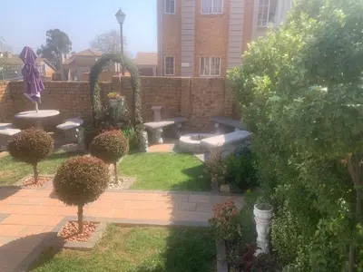 a backyard with a garden with a fountain and benches at Imani's Retreat in Midrand