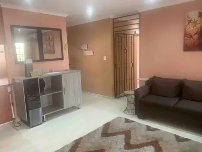 a living room with a couch and a mirror at Imani's Retreat in Midrand