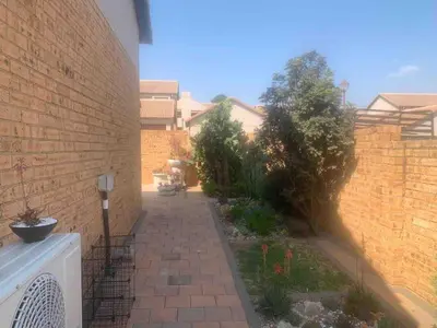 a brick wall with a walkway next to a building at Imani's Retreat in Midrand