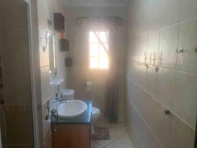 a bathroom with a toilet and a sink and a window at Imani's Retreat in Midrand