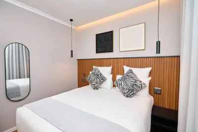 a bedroom with a white bed with two pillows at The Oasis, Unit N110 @ Glen Park in Pretoria