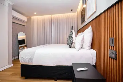 a bedroom with a large bed and a table at The Oasis, Unit N110 @ Glen Park in Pretoria