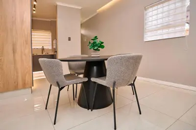 a dining room table with two chairs and a plant on it at The Oasis, Unit N110 @ Glen Park in Pretoria