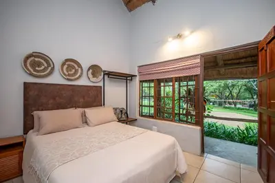 a bedroom with a large bed and a window at Ons Plek Accommodation in Hazyview
