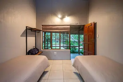 two beds in a room with a window at Ons Plek Accommodation in Hazyview