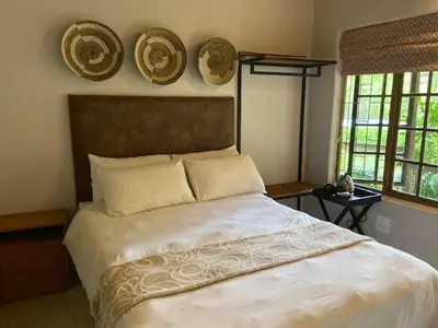 a bedroom with a large bed with hats on the wall at Ons Plek Accommodation in Hazyview