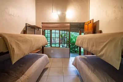 two bunk beds in a room with a window at Ons Plek Accommodation in Hazyview