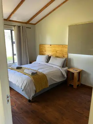 a bedroom with a bed with a wooden headboard at Paradise & Private Padel Court in Dinokeng Game Reserve in Hammanskraal