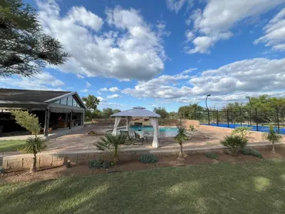 a pavilion with an umbrella next to a pool at Paradise & Private Padel Court in Dinokeng Game Reserve in Hammanskraal