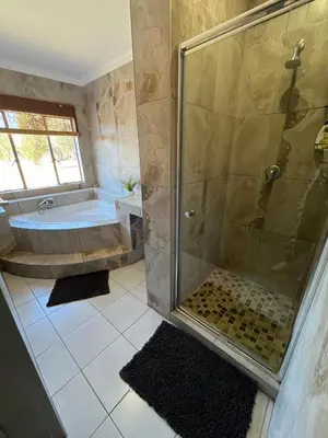 a bathroom with a shower and a tub and a sink at Paradise & Private Padel Court in Dinokeng Game Reserve in Hammanskraal
