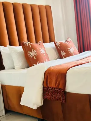 a bed with brown and white sheets and pillows at Beach-Style Bliss at The Blyde in Pretoria
