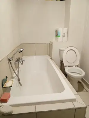 a bathroom with a white tub and a toilet at Patio Executive in Midrand