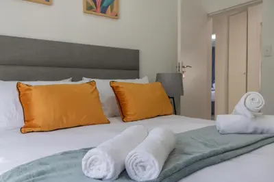 a bedroom with a bed with towels on it at Menlyn Chique Apartment in Pretoria