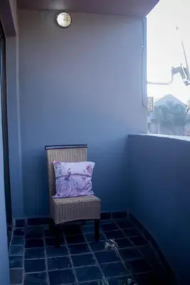 a blue room with a chair with a purple pillow at Midrand Cozy in Midrand
