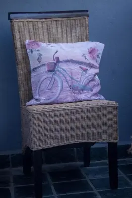 a pillow with a bike on it sitting on a wicker chair at Midrand Cozy in Midrand