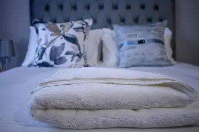 a bed with white blankets and pillows on it at Midrand Cozy in Midrand