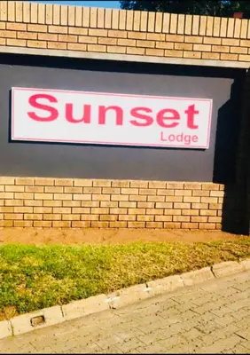 a sign for a sun set lodge on a brick wall at Rekganya Sunset Lodge in Phalaborwa