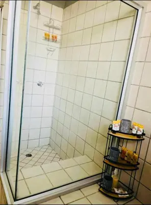a bathroom with a shower with a glass door at Rekganya Sunset Lodge in Phalaborwa
