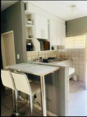 a kitchen with a table and two chairs in it at Rekganya Sunset Lodge in Phalaborwa