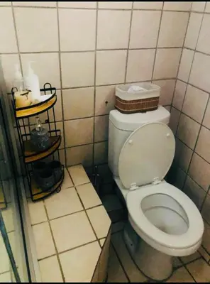 a bathroom with a toilet in a tiled room at Rekganya Sunset Lodge in Phalaborwa