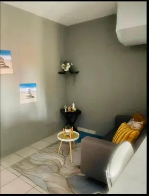 a living room with a couch and a table at Rekganya Sunset Lodge in Phalaborwa