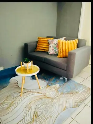 a living room with a couch and a table at Rekganya Sunset Lodge in Phalaborwa