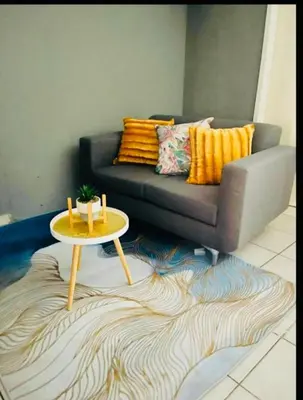 a living room with a couch and a table at Rekganya Sunset Lodge in Phalaborwa