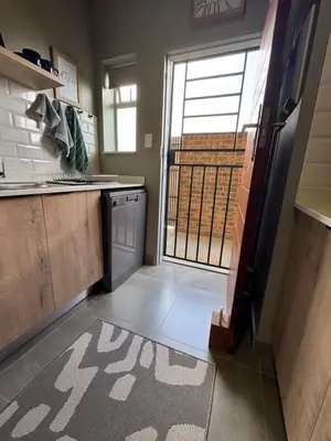 a kitchen with a door open to a balcony at IBella's at The Urban in Pretoria