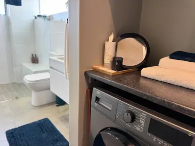 a bathroom with a washing machine and a mirror at IBella's at The Urban in Pretoria