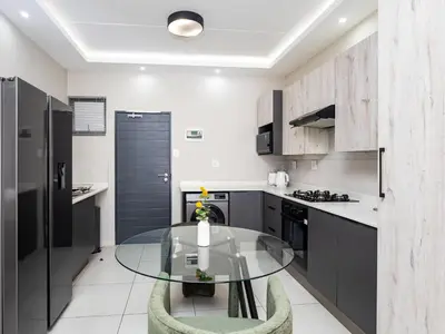 a kitchen with a glass table in a room at Thetan's Home Away From Home in Midrand