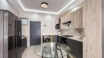 a kitchen with a glass table in a room at Thetan's Home Away From Home in Midrand