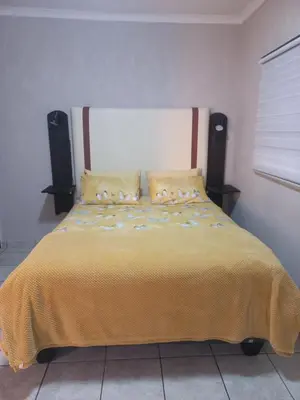 a bedroom with a bed with a yellow blanket and speakers at House at Bethesda in Springs