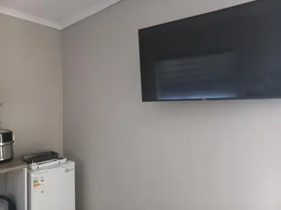 a flat screen tv hanging on a wall next to a refrigerator at House at Bethesda in Springs